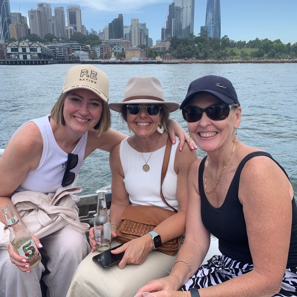 a couple of people that are sitting next to a body of water