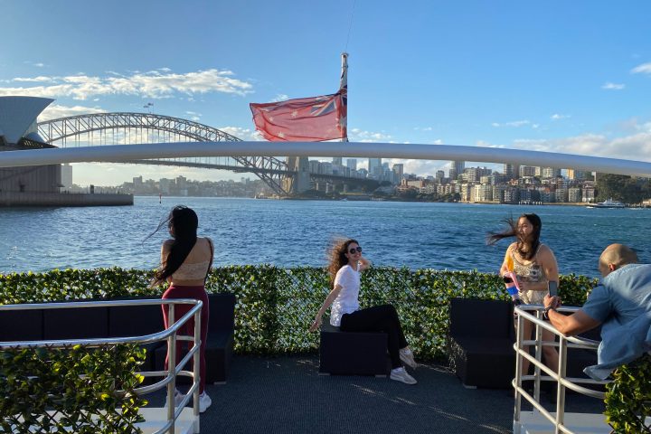 a group of people sitting on a bench next to a body of water