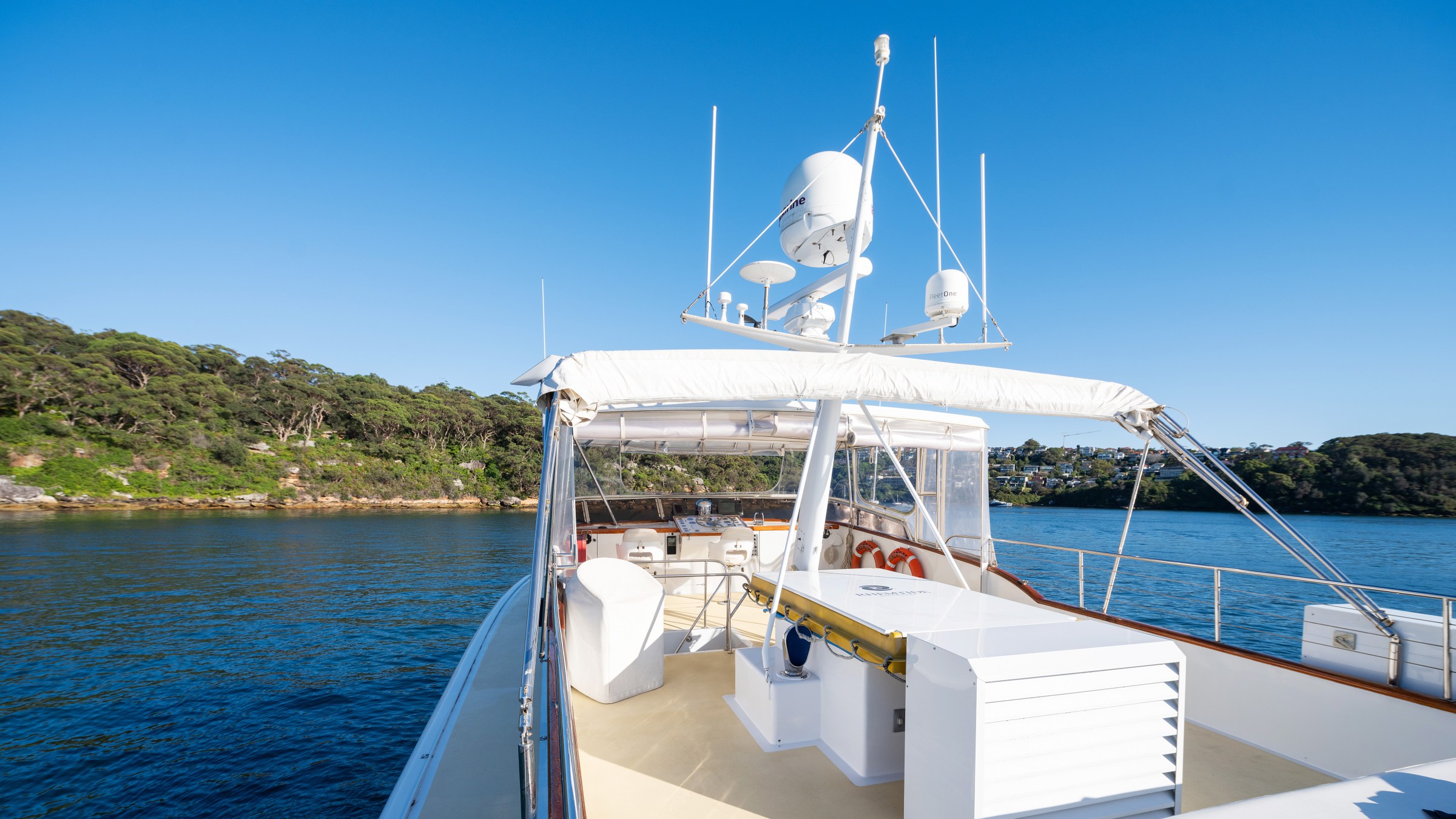 View from a yacht deck with clear sky and coastline in the background.